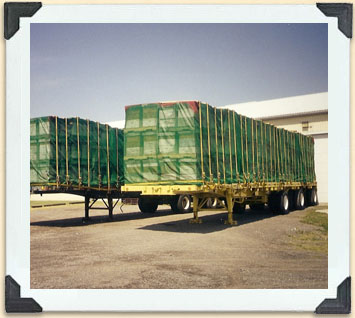 Hives ready to be transported by truck; netting protects the hives and prevents the bees from escaping. 